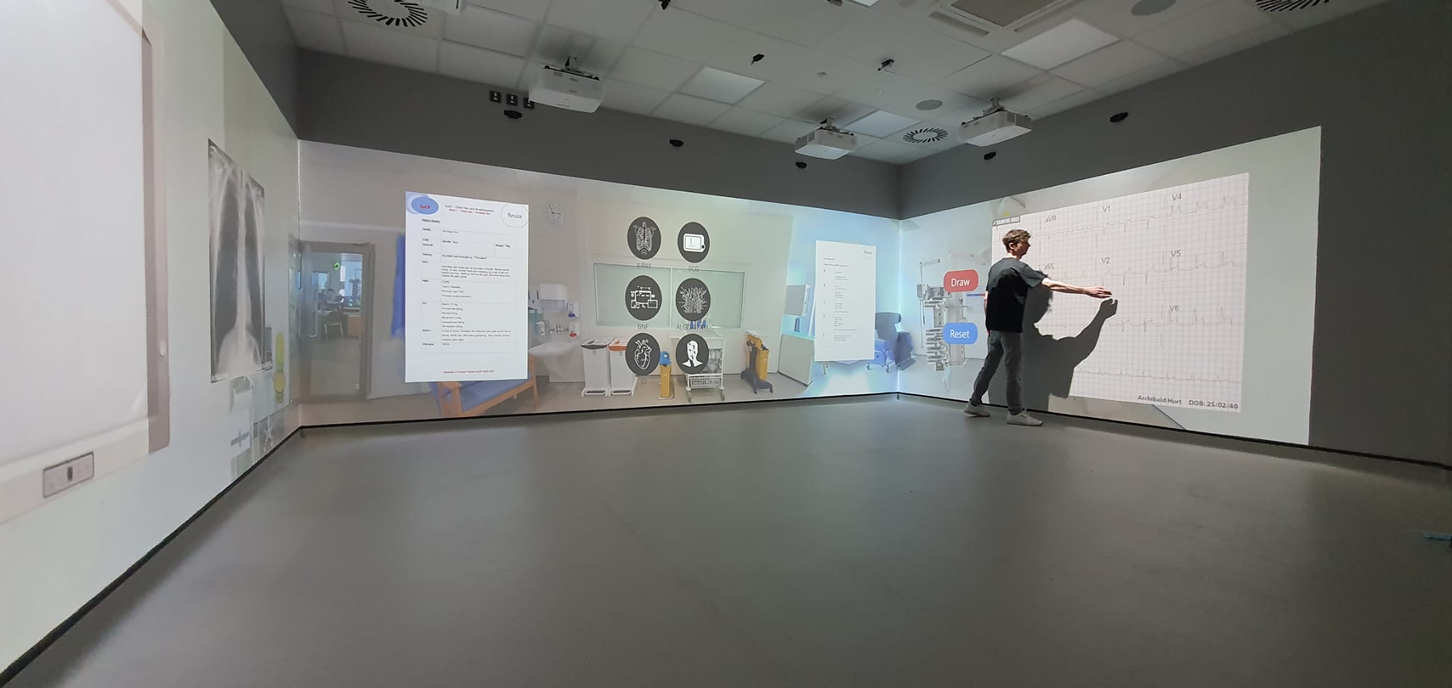 Node XR scenario projected on an immersive corner-projection wall — clinical training simulation